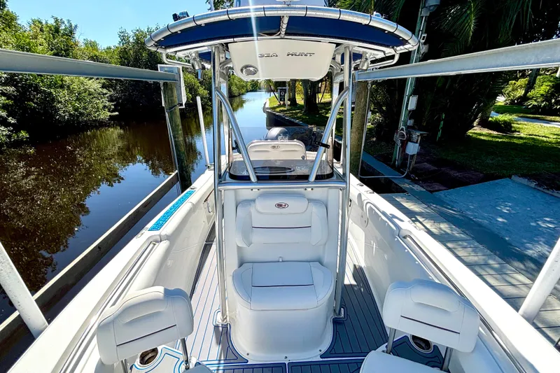 Slide: The Image of 2018 Sea Hunt Ultra 211 boat docked by a scenic waterway, featuring sleek design and comfortable seating. - 67