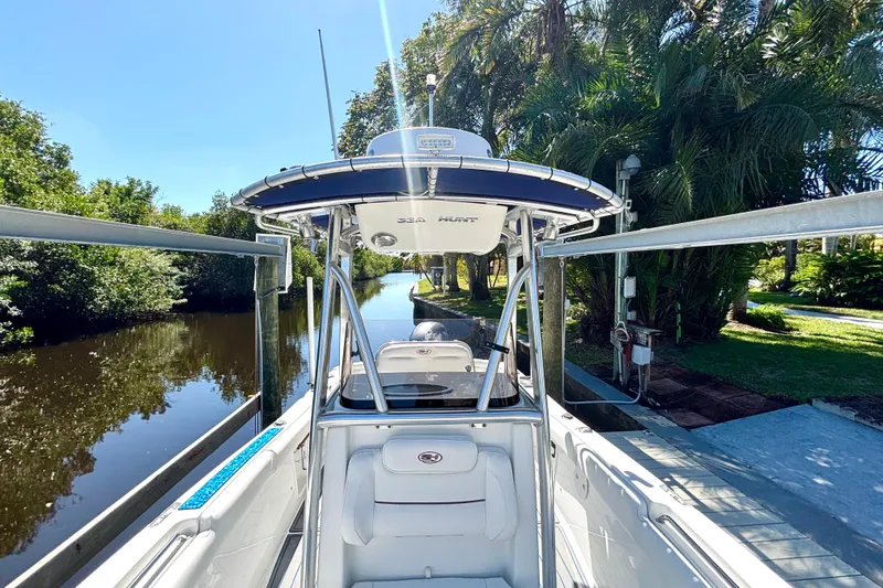 Slide: The Image of 2018 Sea Hunt Ultra 211 boat docked by a lush, tropical waterway. - 71