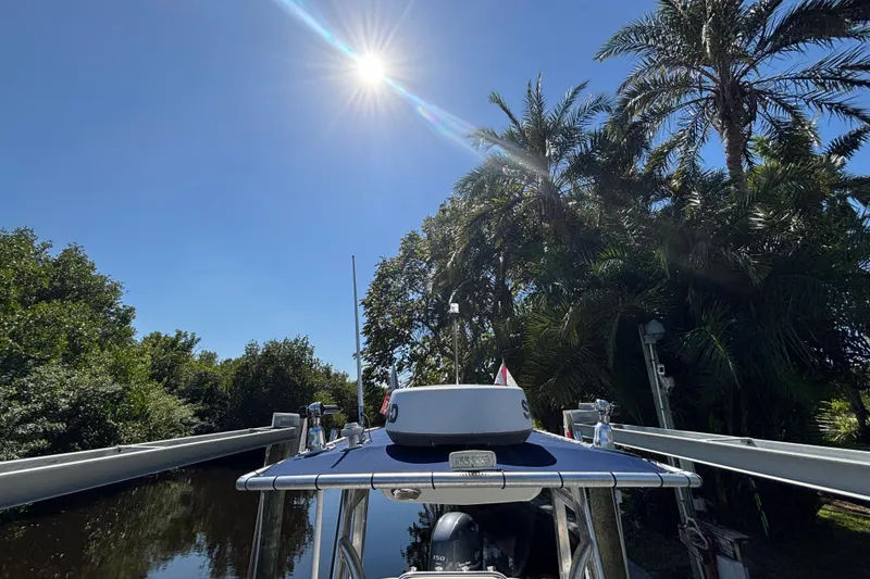 Slide: The Image of 2018 Sea Hunt Ultra 211 boat under bright sun, surrounded by lush palm trees. - 72