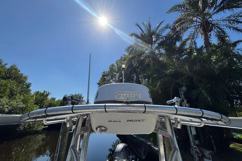 Slide: The Image of 2018 Sea Hunt Ultra 211 boat under bright sun, surrounded by lush palm trees. - 73
