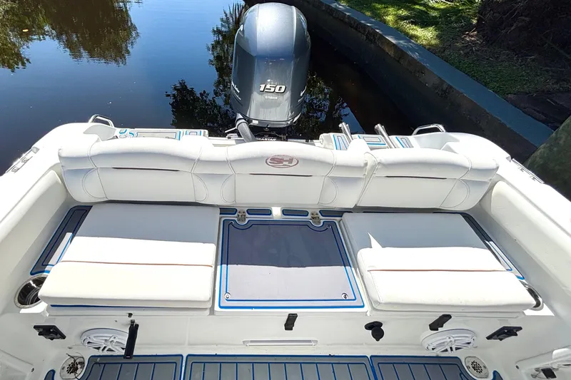 Slide: The Image of 2018 Sea Hunt Ultra 211 boat interior with Yamaha 150 engine, white seating, and blue accents. - 84