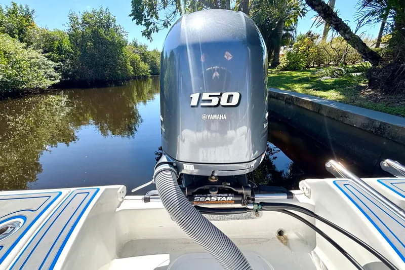 Slide: The Image of 2018 Sea Hunt Ultra 211 boat with Yamaha 150 engine on a calm river. - 89