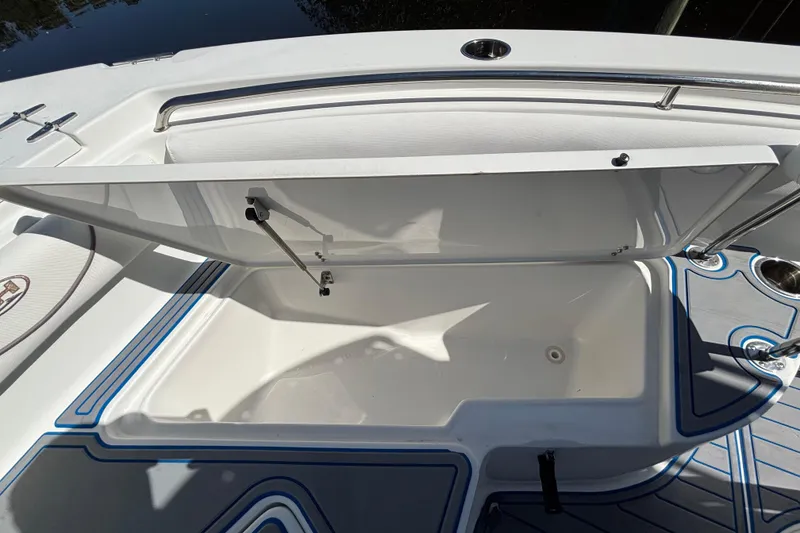 Slide: The Image of Open storage compartment on a 2018 Sea Hunt Ultra 211 boat, featuring sleek design and blue accents. - 91
