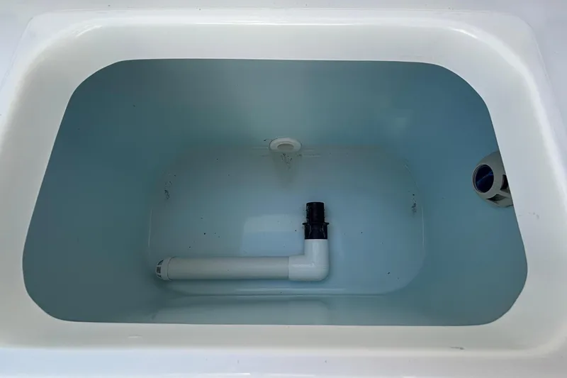Slide: The Image of Livewell compartment in a 2018 Sea Hunt Ultra 211 boat, featuring plumbing fixtures. - 93