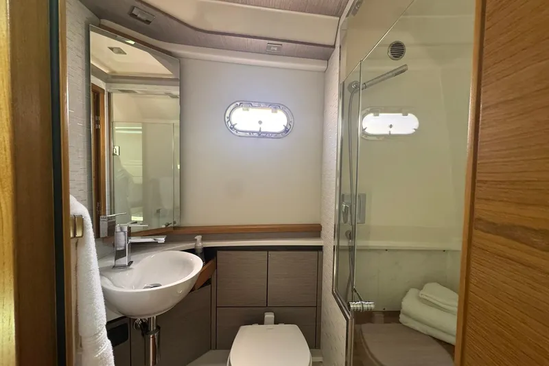 Slide: The Image of 2024 Tiara Yachts 48 LS luxury boat on calm water under blue sky. - 14
