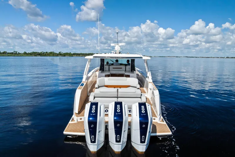 Slide: The Image of 2024 Tiara Yachts 48 LS on calm water, featuring triple 600 V12 engines. - 19