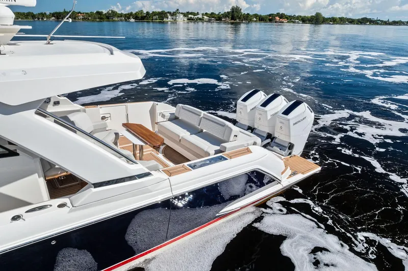 Slide: The Image of 2024 Tiara Yachts 48 LS luxury boat with triple Mercury engines on calm water. - 21