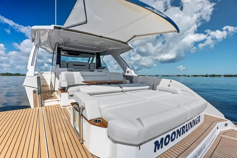 Slide: The Image of 2024 Tiara Yachts 48 LS luxury yacht with spacious deck and seating, under clear blue sky. - 32