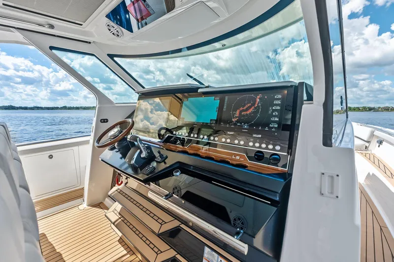 Slide: The Image of 2024 Tiara Yachts 48 LS helm with advanced navigation system, overlooking serene waters. - 34