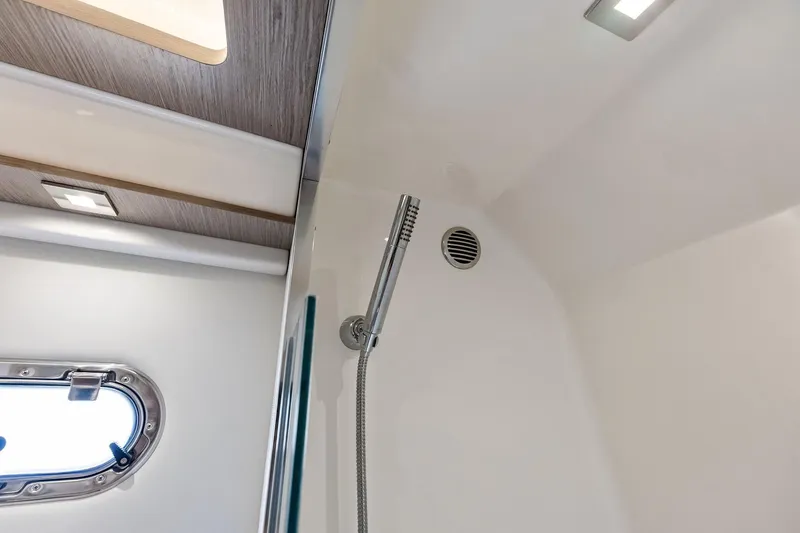 Slide: The Image of 2024 Tiara Yachts 48 LS shower area with modern fixtures and porthole window. - 47