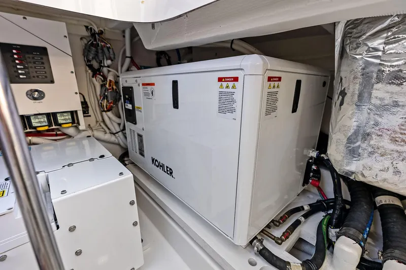 Slide: The Image of Engine room of 2024 Tiara Yachts 48 LS featuring Kohler generator and electrical components. - 53