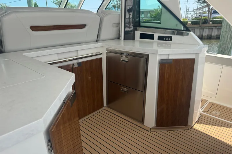 Slide: The Image of 2024 Tiara Yachts 48 LS cruising on open water under a cloudy sky. - 8