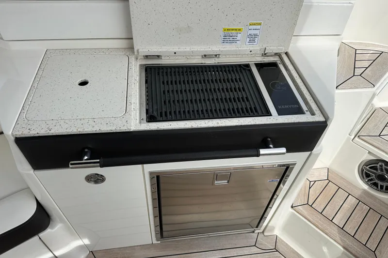 Slide: The Image of 2019 Sea Ray SLX 350 Outboard boat kitchen with Kenyon grill and storage. - 15