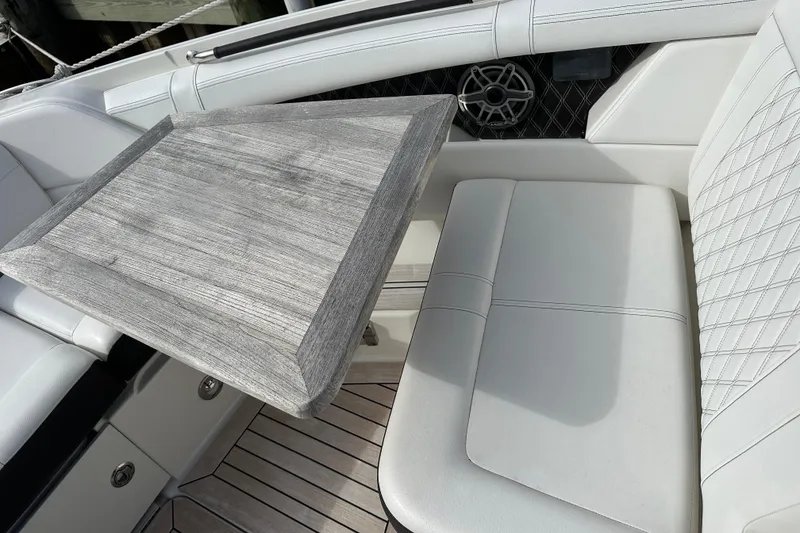 Slide: The Image of 2019 Sea Ray SLX 350 Outboard interior with wooden table and white seating. - 17