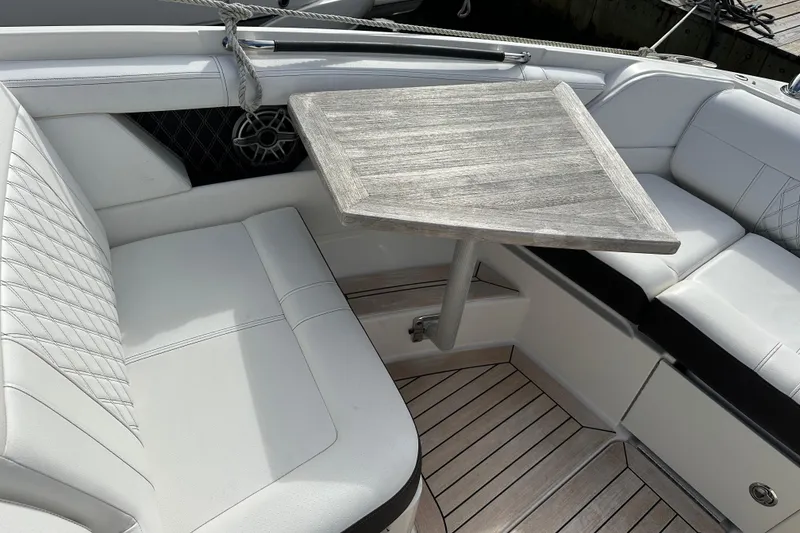 Slide: The Image of Luxurious seating area on 2019 Sea Ray SLX 350 Outboard with wooden table and white upholstery. - 19