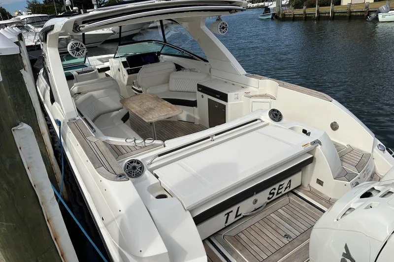 Slide: The Image of 2019 Sea Ray SLX 350 Outboard boat docked, featuring spacious seating and sleek design. - 2