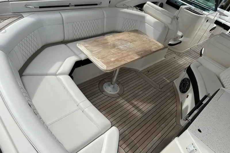 Slide: The Image of 2019 Sea Ray SLX 350 Outboard interior with elegant seating and wooden table. - 20