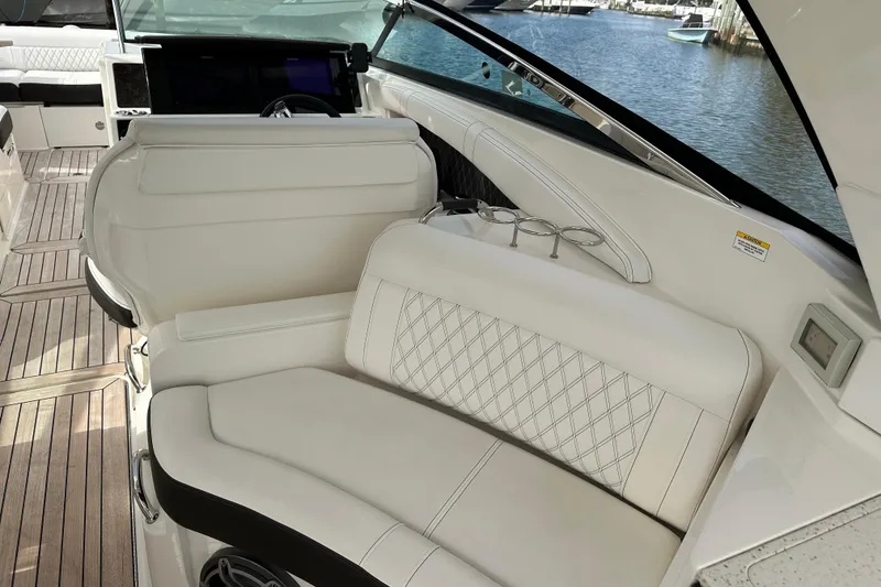 Slide: The Image of 2019 Sea Ray SLX 350 Outboard interior with white leather seating and wood flooring. - 23