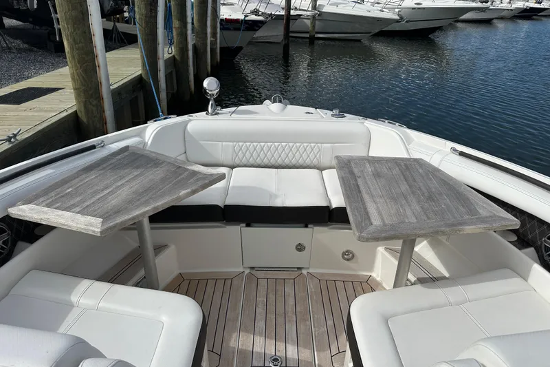 Slide: The Image of 2019 Sea Ray SLX 350 Outboard interior with dual tables and white seating at marina. - 3