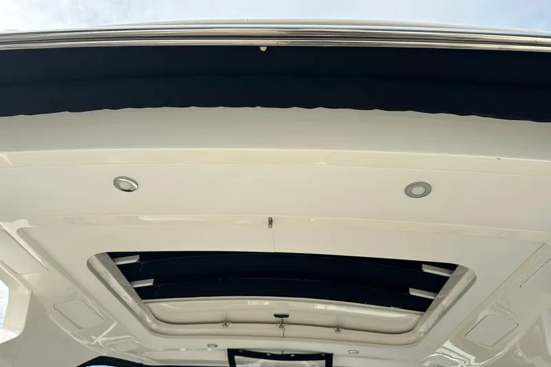 Slide: The Image of 2019 Sea Ray SLX 350 Outboard boat roof with recessed lighting and open sunroof. - 31