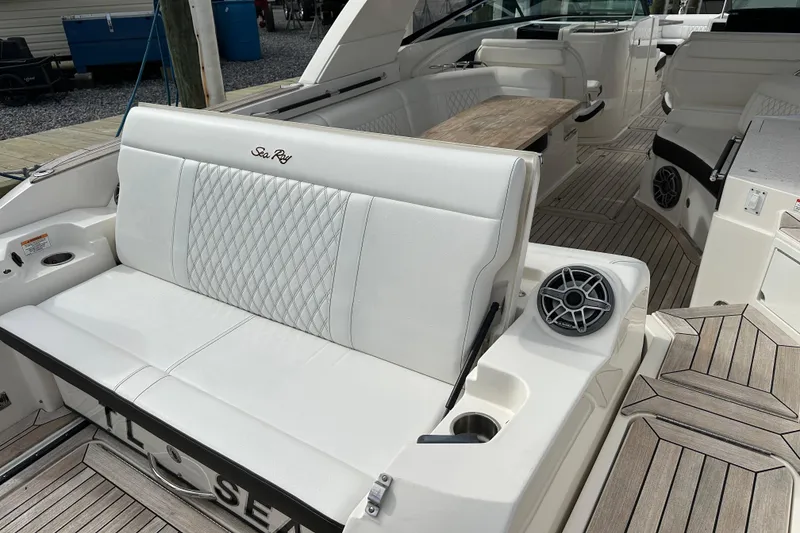 Slide: The Image of 2019 Sea Ray SLX 350 Outboard interior with white seating and wood accents. - 4