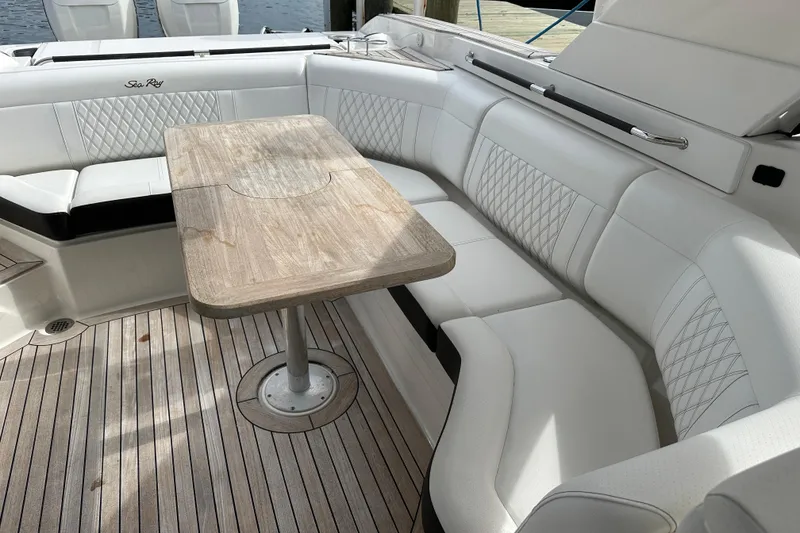 Slide: The Image of Luxurious seating area on 2019 Sea Ray SLX 350 Outboard with wooden table and white upholstery. - 8