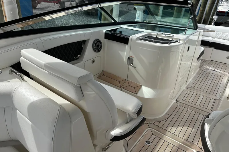 Slide: The Image of 2019 Sea Ray SLX 350 Outboard interior with white seating and wooden flooring. - 9