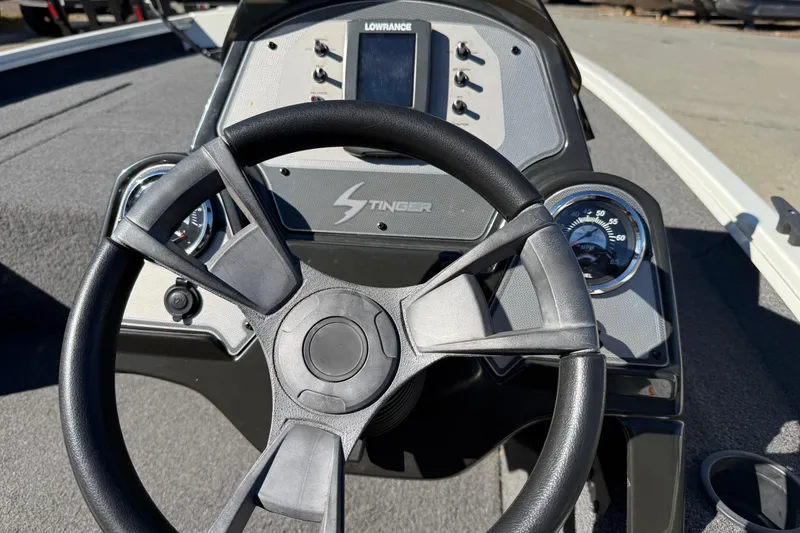 Slide: The Image of Steering wheel and dashboard of 2018 Lowe Stinger 175C boat, featuring gauges and controls. - 10