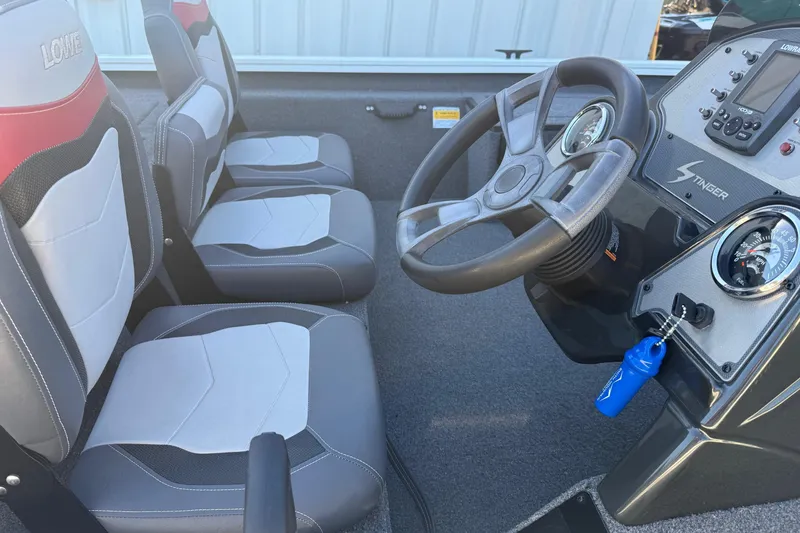 Slide: The Image of 2018 Lowe Stinger 175C boat interior with steering wheel, dashboard, and two seats. - 14