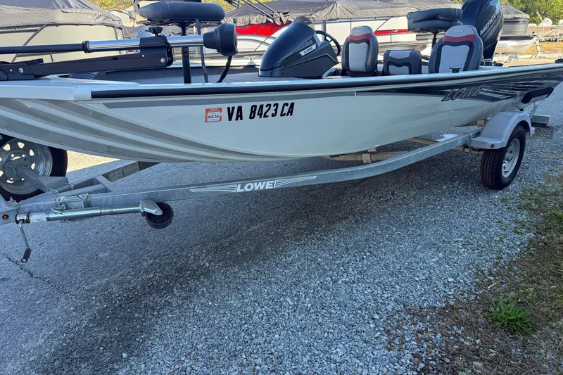 Slide: The Image of 2018 Lowe Stinger 175C fishing boat on trailer, parked on gravel. - 2