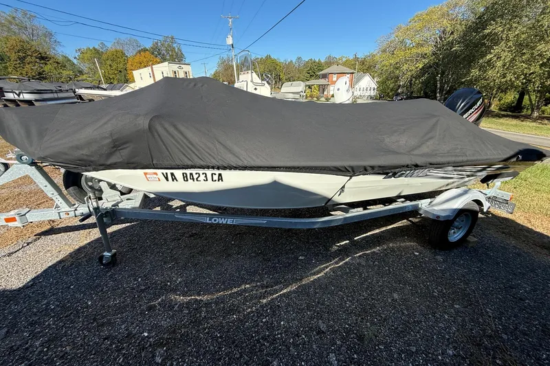 Slide: The Image of 2018 Lowe Stinger 175C boat covered on trailer, parked outdoors. - 5