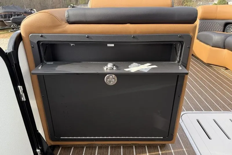 Slide: The Image of Storage compartment on 2026 Premier 230 Sunsation boat with brown seating and wood flooring. - 18