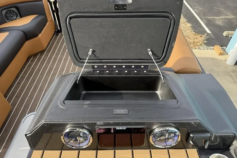 Slide: The Image of 2026 Premier 230 Sunsation boat dashboard with open storage compartment and gauges. - 22