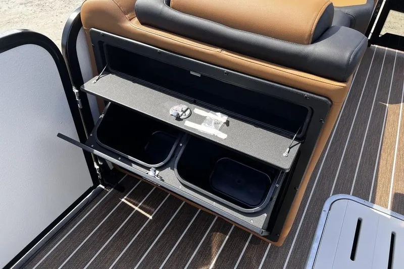 Slide: The Image of Interior storage compartment of 2026 Premier 230 Solaris boat with open lid and cup holders. - 24