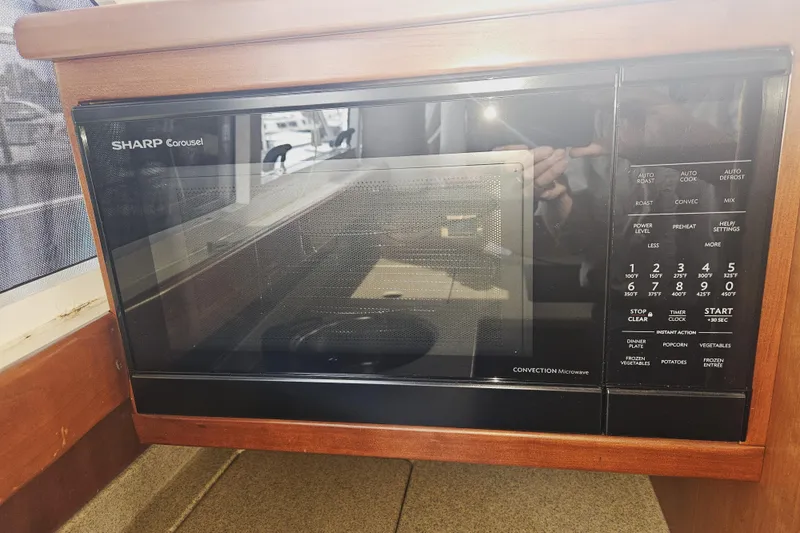 Slide: The Image of 2000 Cruisers Yachts 4450 Express Motoryacht kitchen with dual sinks and wooden cabinetry. - 26