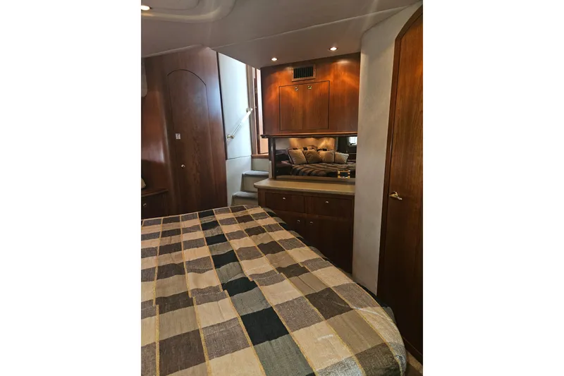 Slide: The Image of Luxurious bedroom interior of 2000 Cruisers Yachts 4450 Express Motoryacht with plaid bedding. - 31