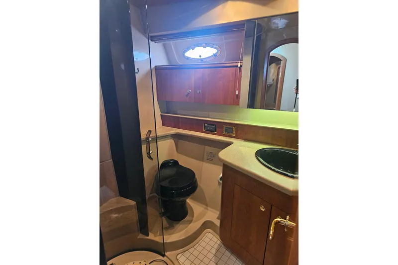 Slide: The Image of Interior of 2000 Cruisers Yachts 4450 Express Motoryacht with wooden cabinetry and patterned bedding. - 48