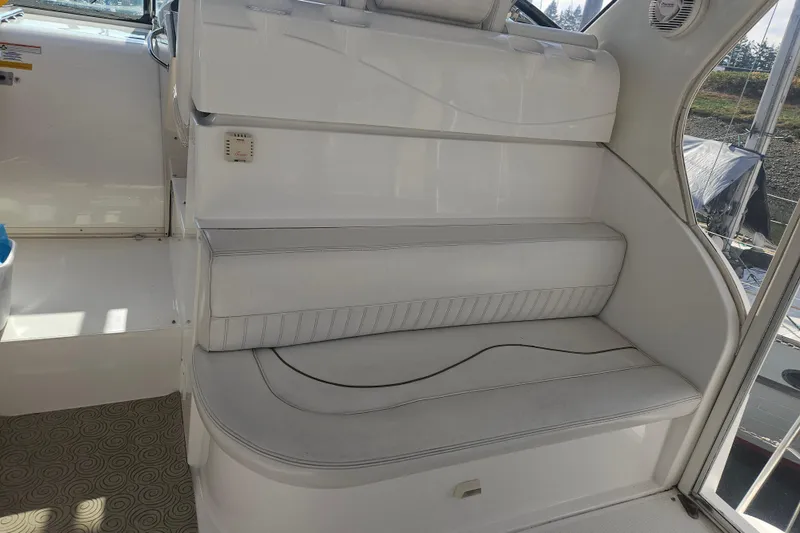 Slide: The Image of 2000 Cruisers Yachts 4450 Express Motoryacht interior with curved seating and wooden table. - 7