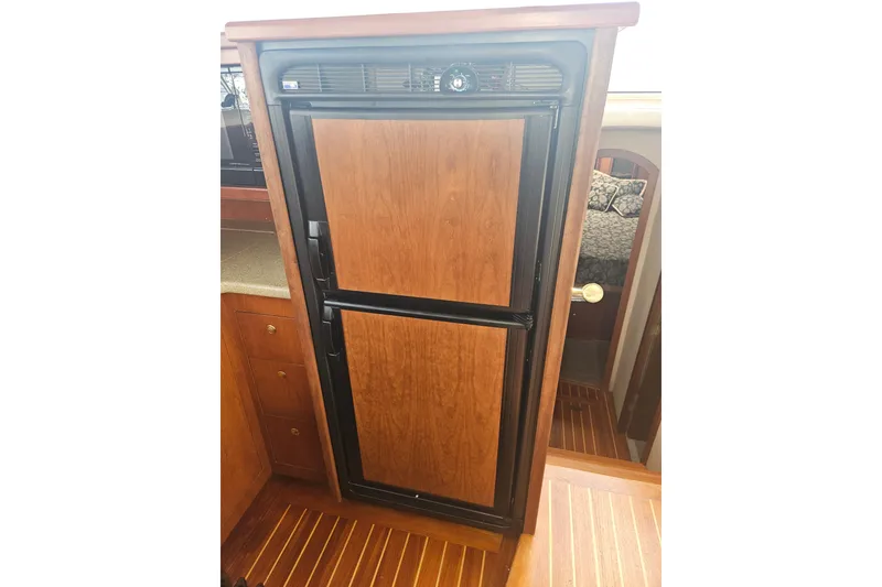 Slide: The Image of 2000 Cruisers Yachts 4450 Express Motoryacht kitchen with stove, sink, and wooden cabinetry. - 25