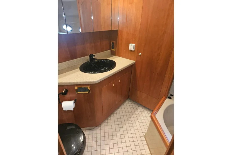 Slide: The Image of Storage closet inside 2000 Cruisers Yachts 4450 Express Motoryacht, featuring wooden shelves and equipment. - 39
