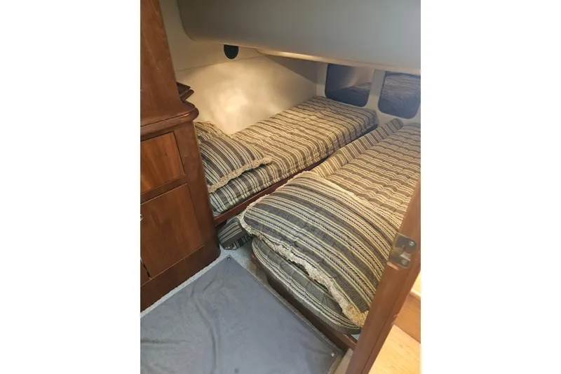 Slide: The Image of Interior of 2000 Cruisers Yachts 4450 Express Motoryacht with patterned bedding and wooden storage. - 46