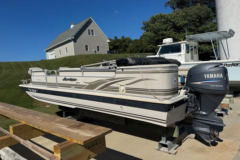 The Image of 2003 Hurricane FunDeck 226 boat with Yamaha outboard motor on a trailer. - 1