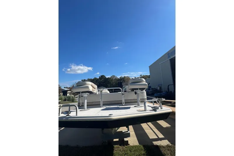 Slide: The Image of 2003 Hurricane FunDeck 226 boat under clear blue sky near a storage facility. - 3