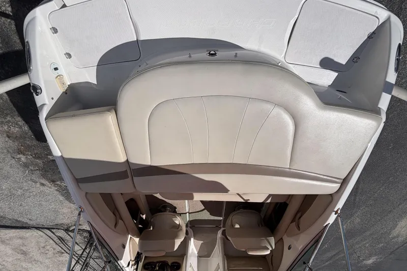 Slide: The Image of 2004 Chaparral 210 SSi boat interior with beige seating and storage compartments. - 14
