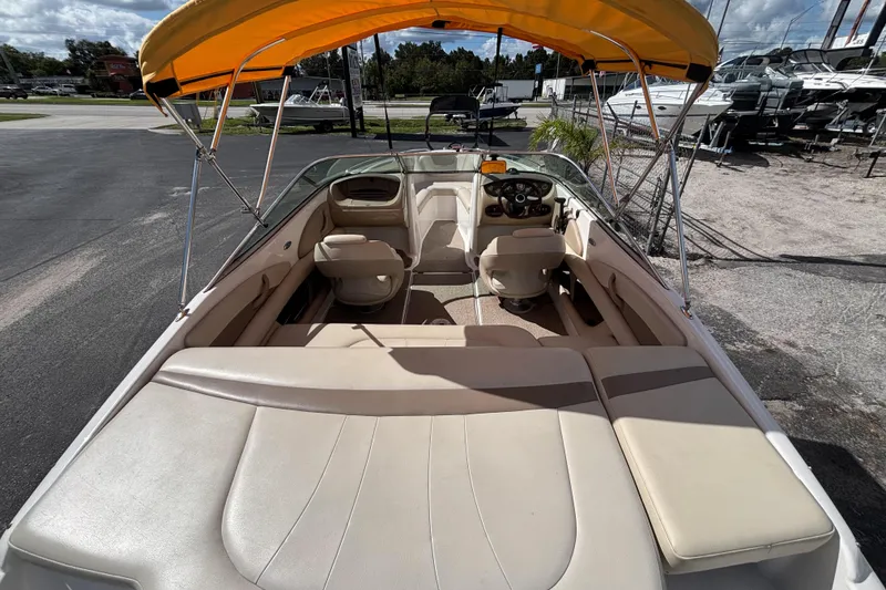 Slide: The Image of 2004 Chaparral 210 SSi boat interior with yellow canopy, beige seating, and steering console. - 15