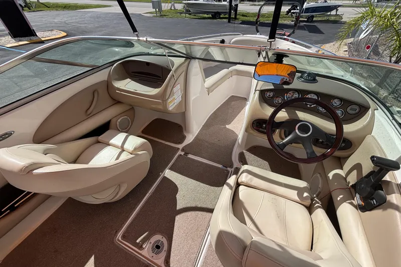 Slide: The Image of 2004 Chaparral 210 SSi boat interior with beige seating and dashboard controls. - 17