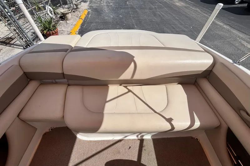 Slide: The Image of 2004 Chaparral 210 SSi boat interior with beige seating and sunlit deck. - 24