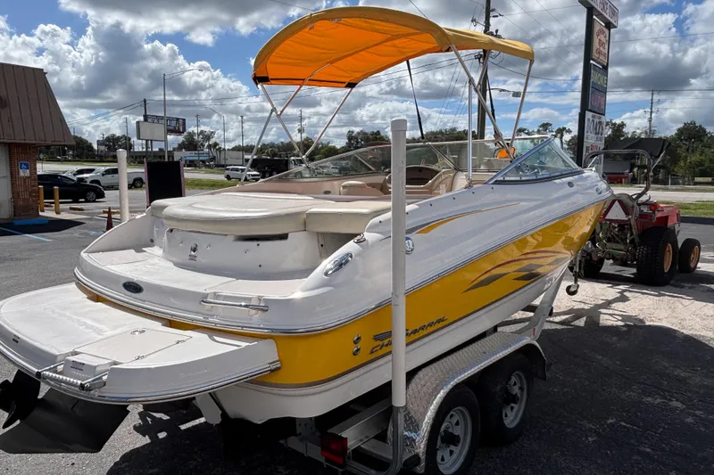 Slide: The Image of 2004 Chaparral 210 SSi boat with yellow accents on a trailer, parked outdoors. - 4
