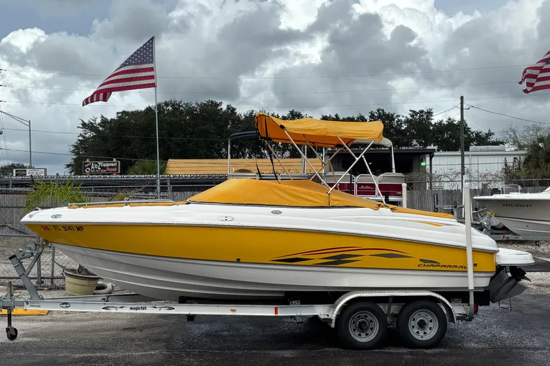 Slide: The Image of 2004 Chaparral 210 SSi boat with yellow cover on trailer, American flags in background. - 41