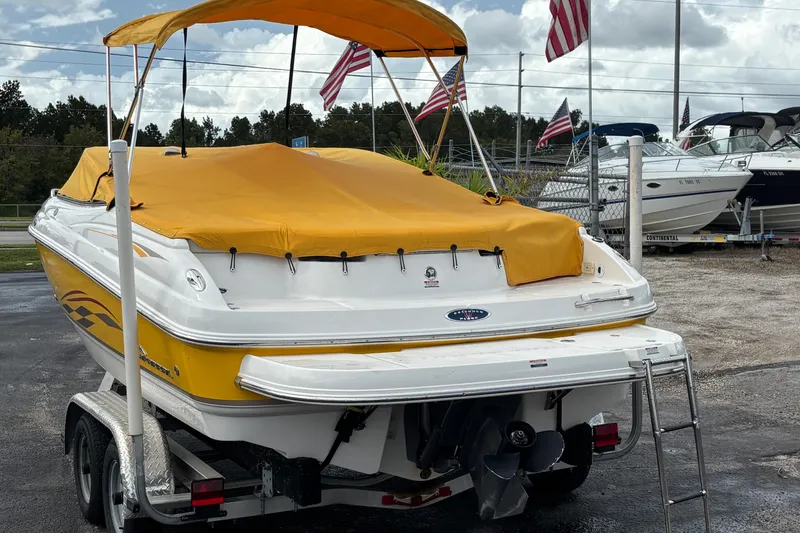Slide: The Image of 2004 Chaparral 210 SSi boat with yellow cover and canopy, parked on a trailer. - 43